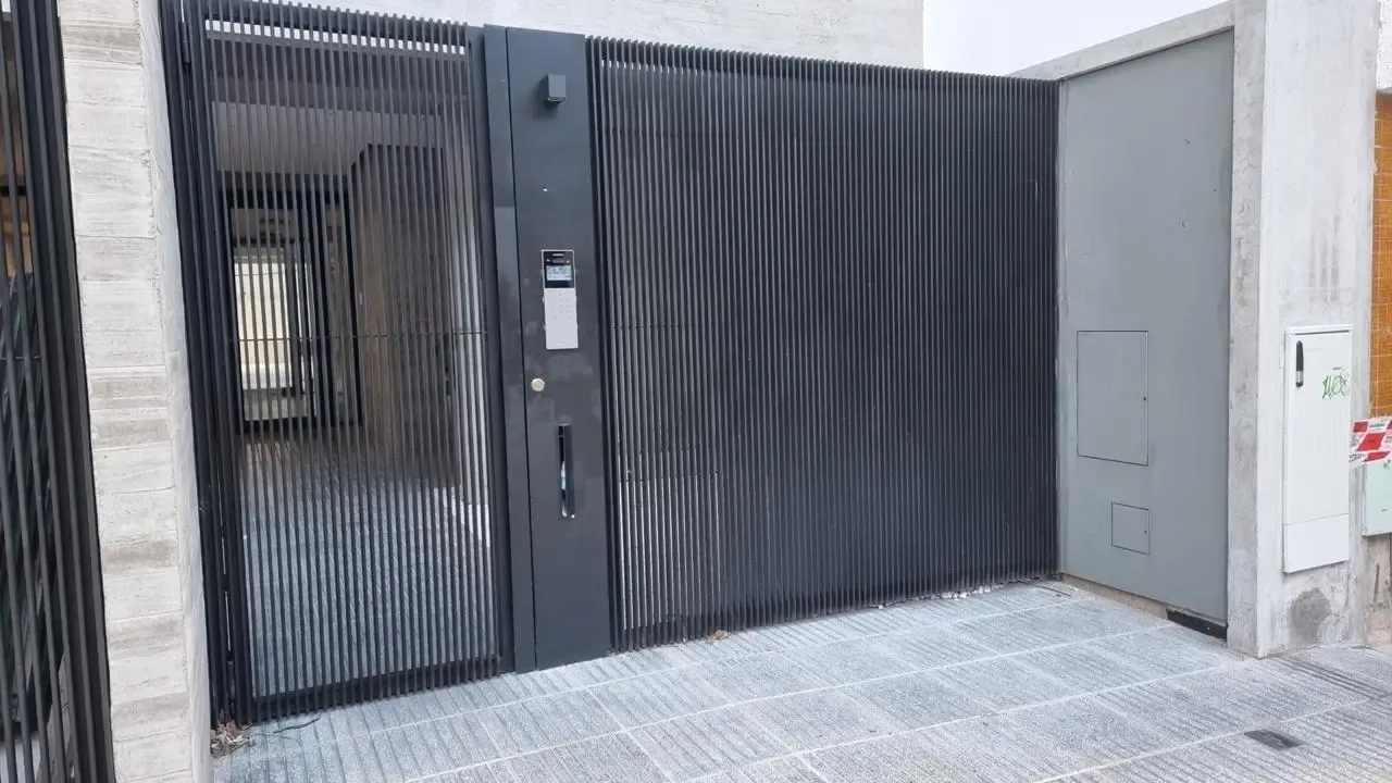 Portón corredizo moderno con tótem de acceso vehicular